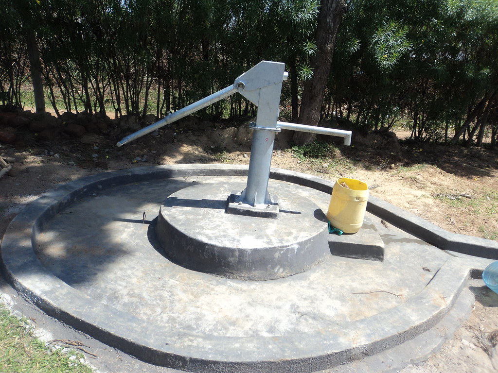 Hand pump on a concrete apron at a community borehole project in Kenya