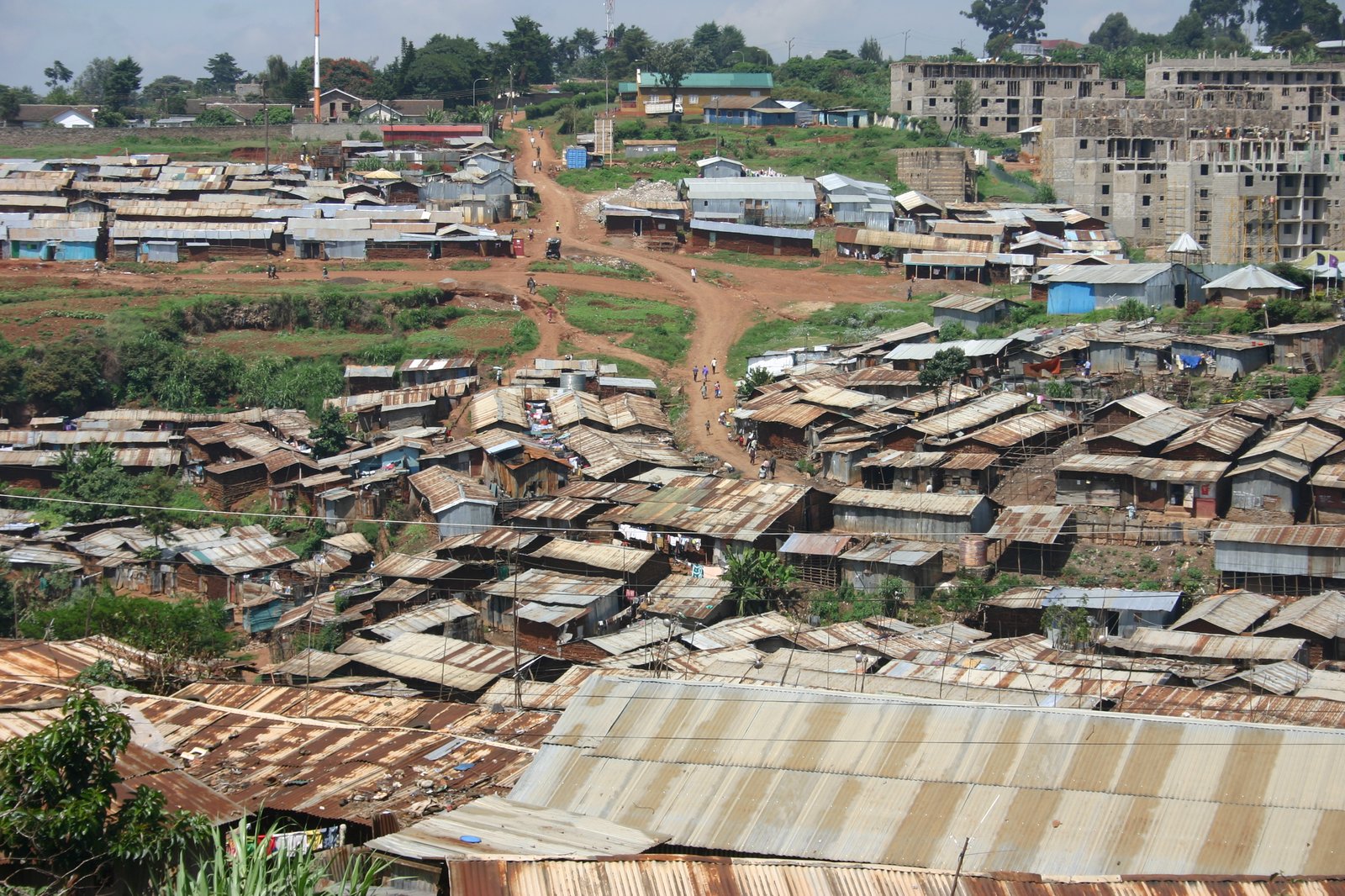 Rooftops of Kibera informal settlement in Nairobi with new apartment blocks rising behind