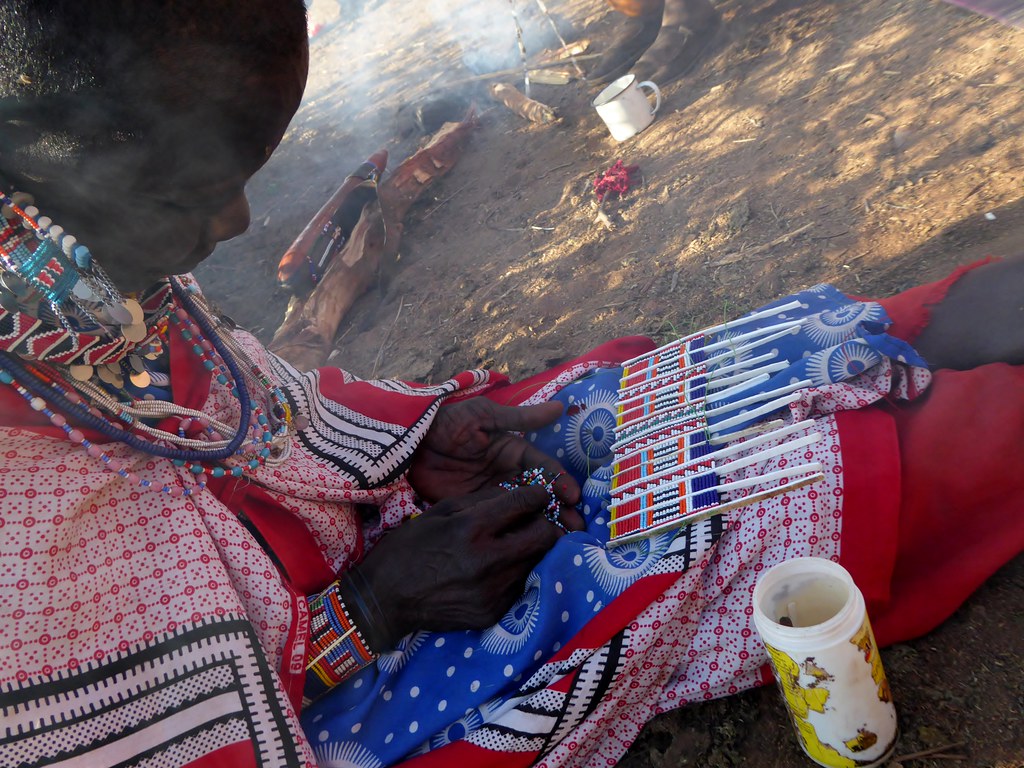 Maasai woman's hands doing traditional beadwork craft training in Kenya
