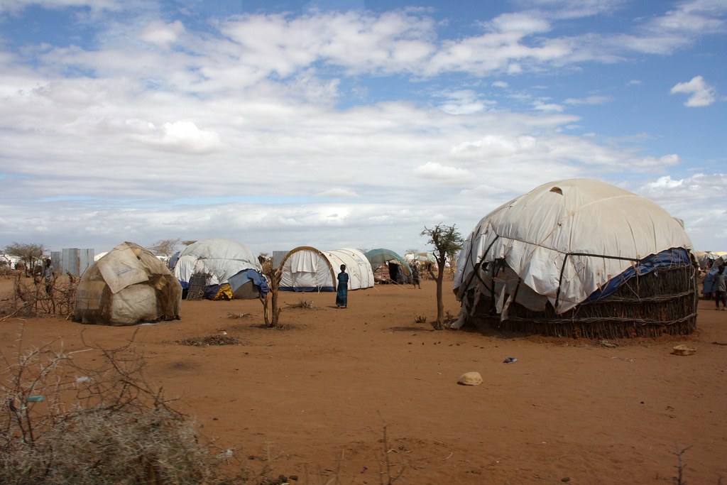 Makeshift refugee shelters on red dry ground at Dadaab camp, northern Kenya, as refugee aid cuts bite in 2026