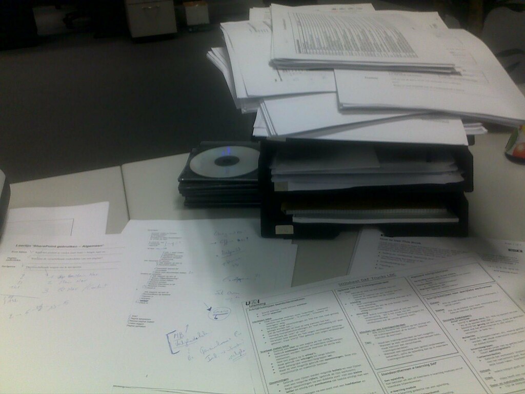 Stacks of paperwork on an office desk for an NGO PBO Act transition records update